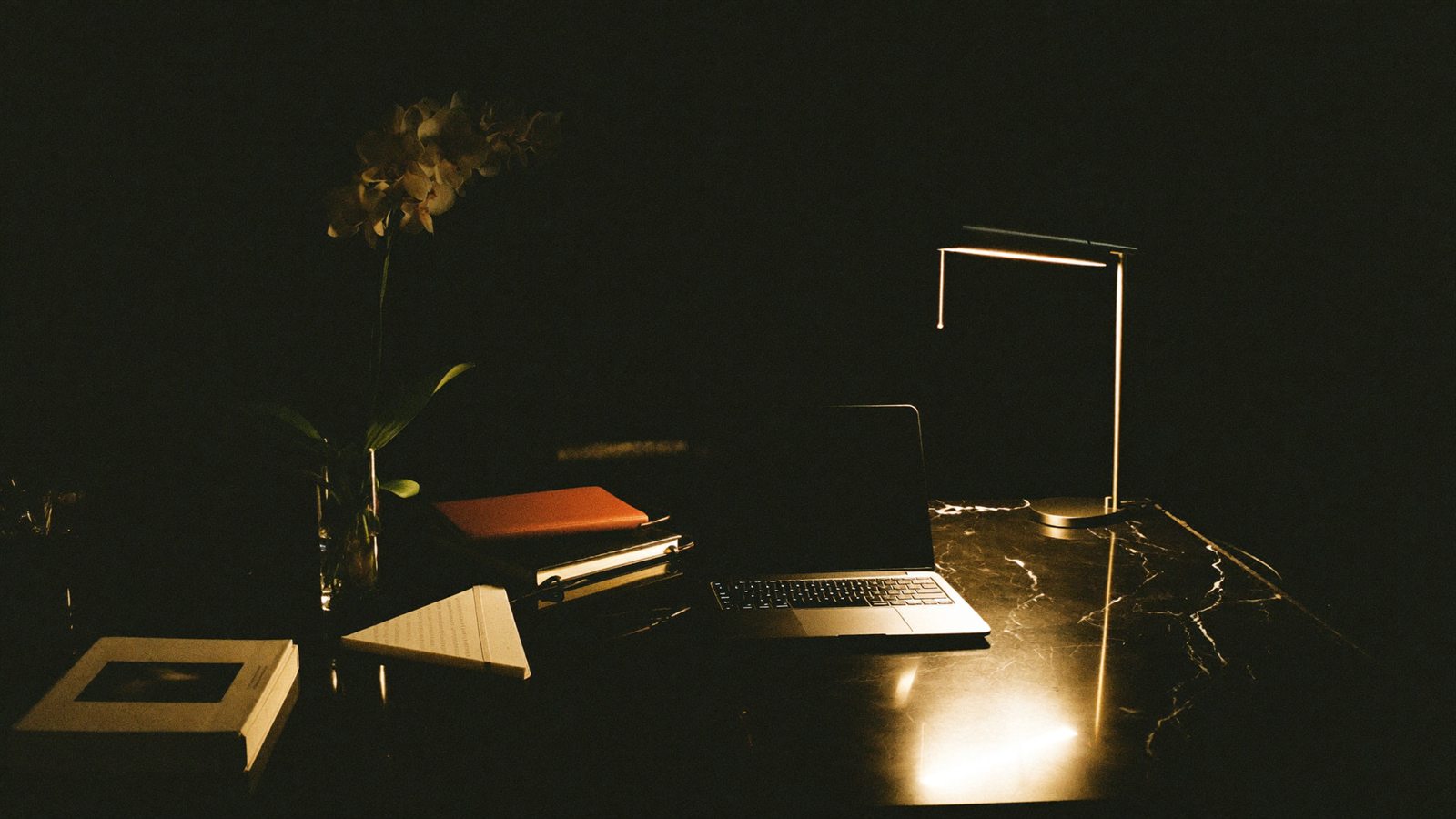 Dunkler eleganter Arbeitsplatz mit warmem Licht